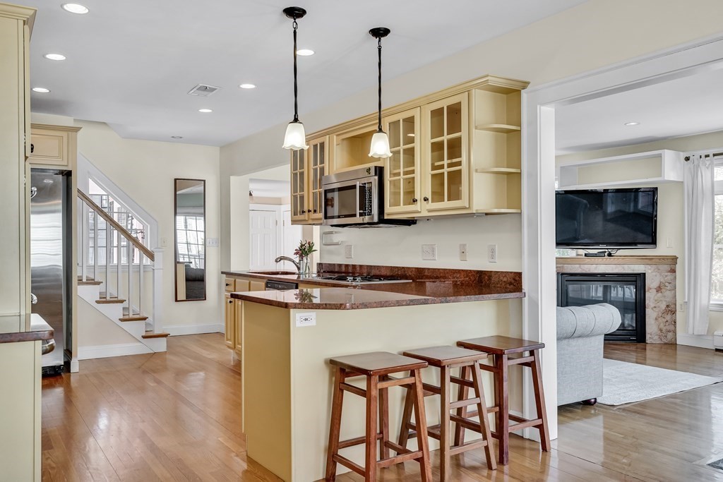 36 Sunset Road Wellesley, MA 02482 - Photo 7 of 30 a kitchen with stainless steel appliances granite countertop a stove top oven a sink a dining table and chairs with wooden floor