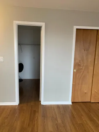 an empty room with wooden floor and closet