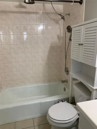 a white toilet and tub sitting next to a bathroom sink