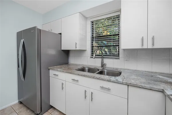 a kitchen with granite countertop white cabinets and white appliances