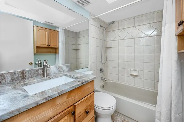 a bathroom with a granite countertop sink and a toilet