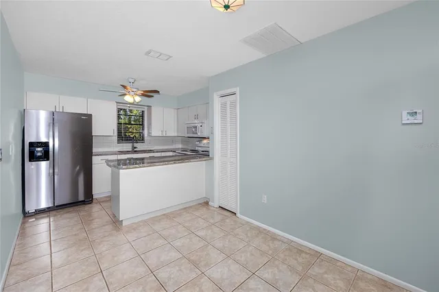 a kitchen with stainless steel appliances granite countertop a sink a refrigerator and a stove