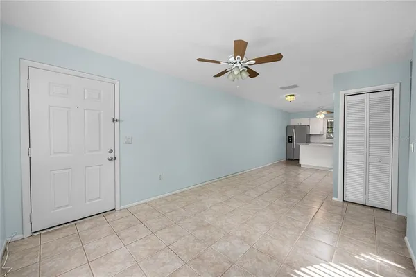 a view of a livingroom with a ceiling fan & entryway