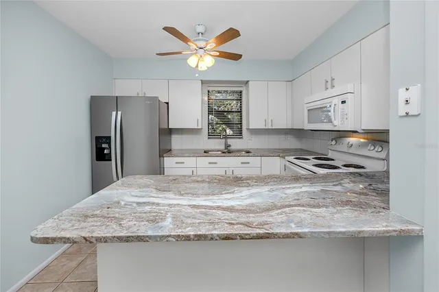a kitchen with granite countertop sink and cabinets