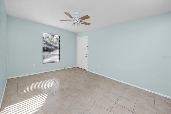an empty room with windows and fan