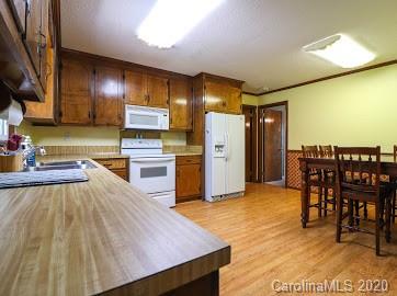 377 Stone Road Salisbury, NC 28146 - Photo 6 of 25 a kitchen with stainless steel appliances kitchen island granite countertop a table chairs in it and wooden floors