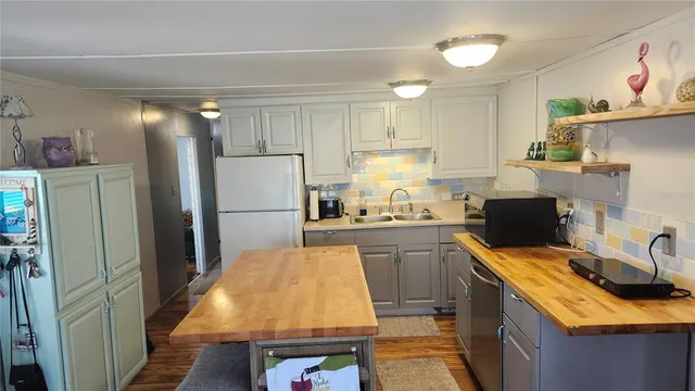 a kitchen with a refrigerator sink and wooden cabinets