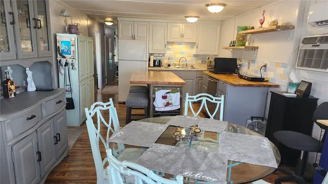 a kitchen with stainless steel appliances granite countertop a table chairs in it and wooden floors