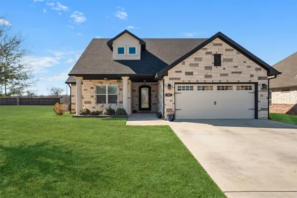 a view of a big house with a big yard and potted plants