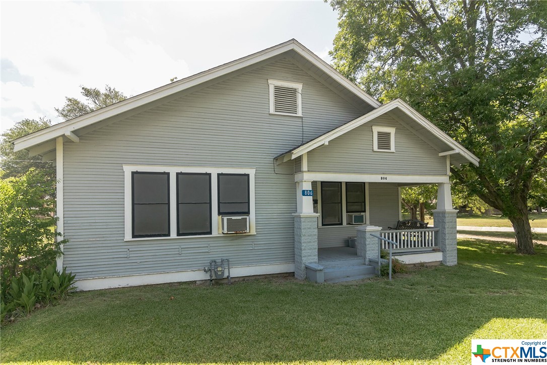 a front view of a house with a garden and yard