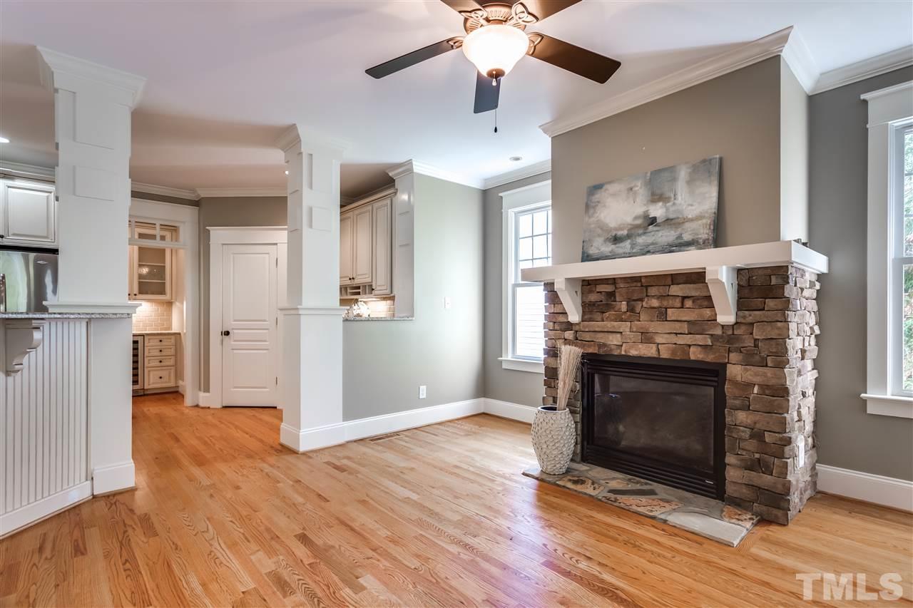 4214 Batiste Road Raleigh, NC 27613 - Photo 17 of 25 a view of an empty room with wooden floor and a fireplace