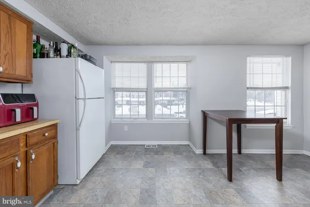 a view of kitchen with refrigerator cabinets and wooden floor