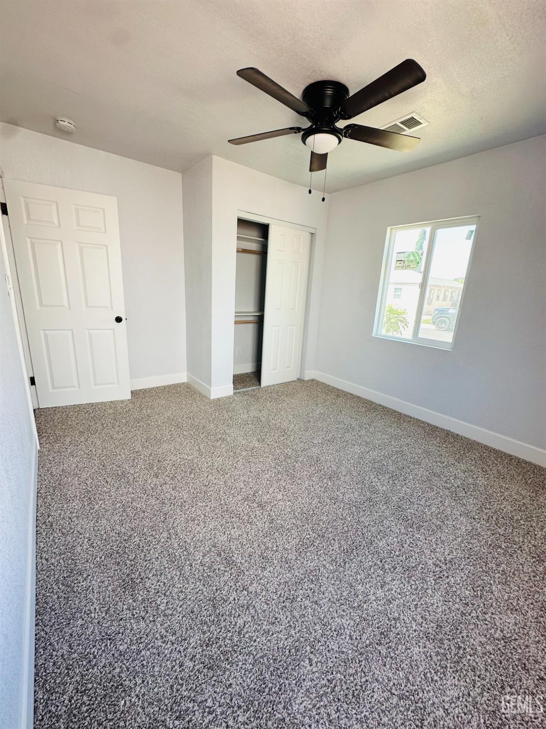 Undisclosed Address Delano, CA 93215 - Photo 8 of 20 an empty room with ceiling fan and window