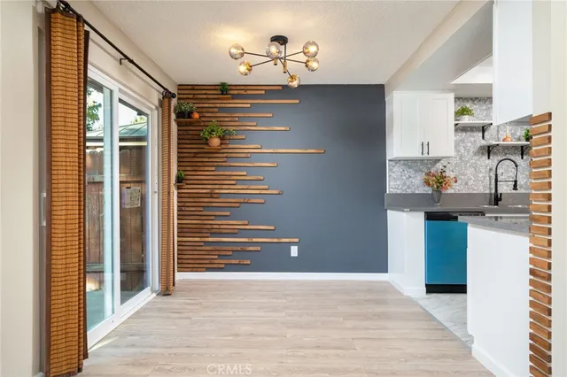 a view of a hallway with dining table and chairs