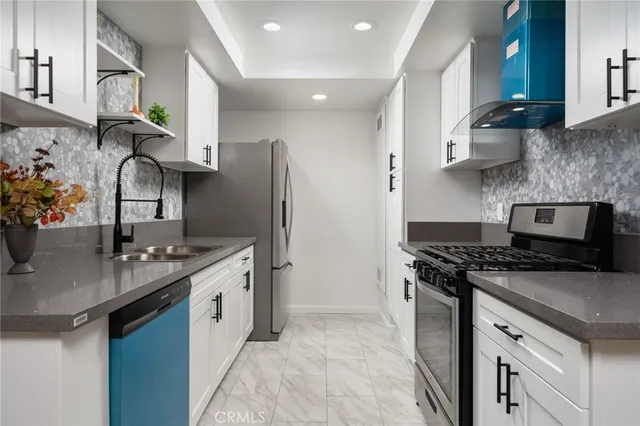 a kitchen with stainless steel appliances granite countertop a sink stove and refrigerator