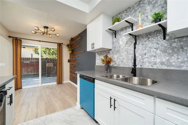 a kitchen with stainless steel appliances granite countertop a sink a stove and a wooden floors