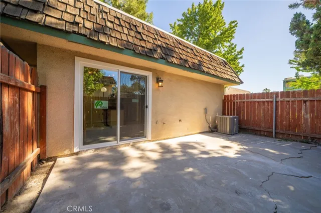 a view of backyard with sliding door and wooden fence