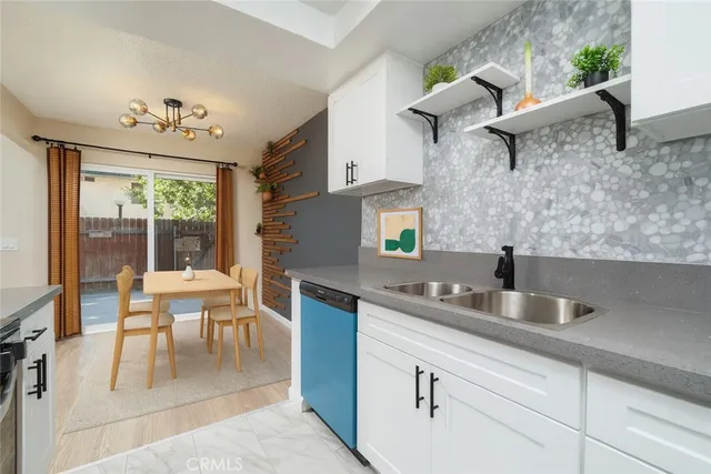 a kitchen with stainless steel appliances a sink a table and chairs in it