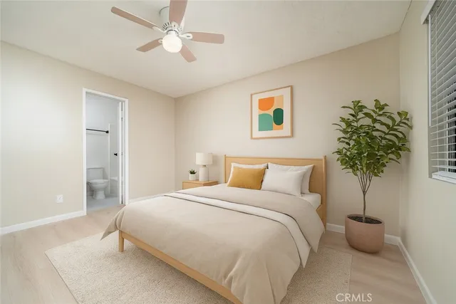 a bedroom with a large bed and a potted plant
