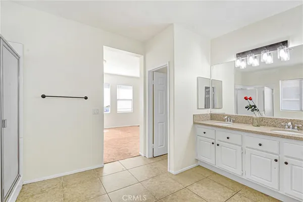 a spacious bathroom with a mirror sink and shower