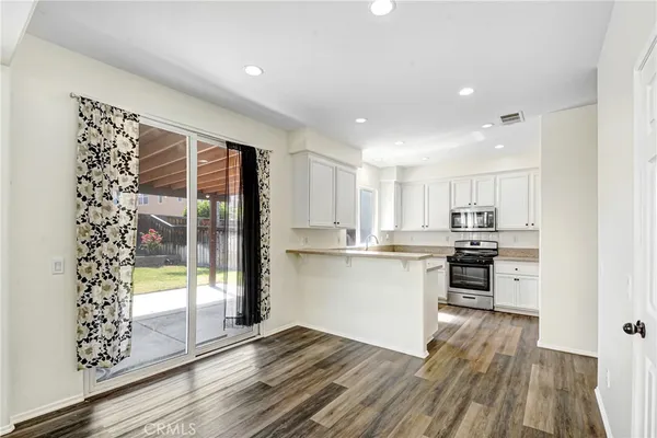 a kitchen with a refrigerator and a stove top oven