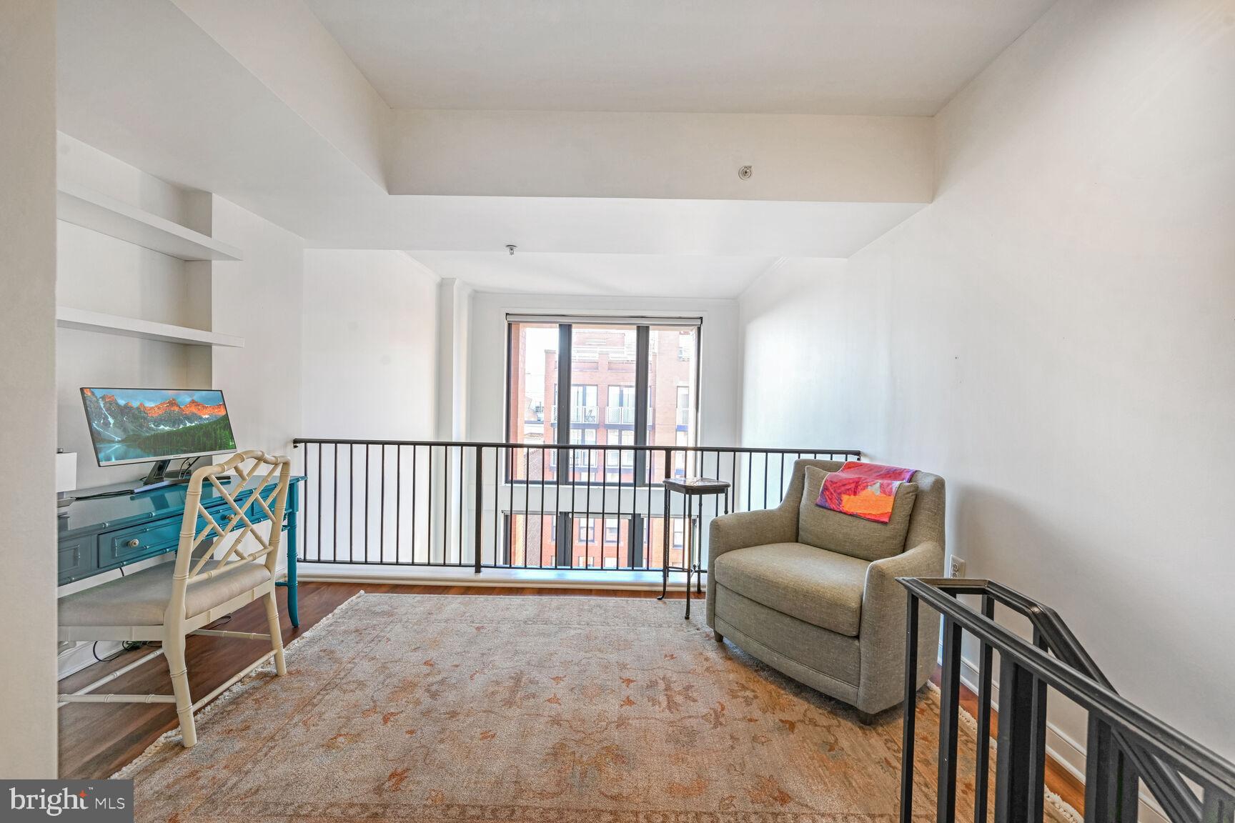 616 E Street Northwest, Unit 1150 Washington, DC 20004 - Photo 13 of 75 a living room with furniture a flat screen tv and a floor to ceiling window
