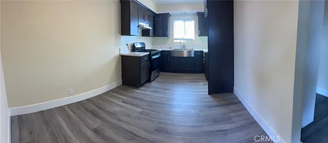 a kitchen with wooden floors and black appliances
