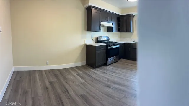 a kitchen with kitchen island wooden floors appliances and cabinets