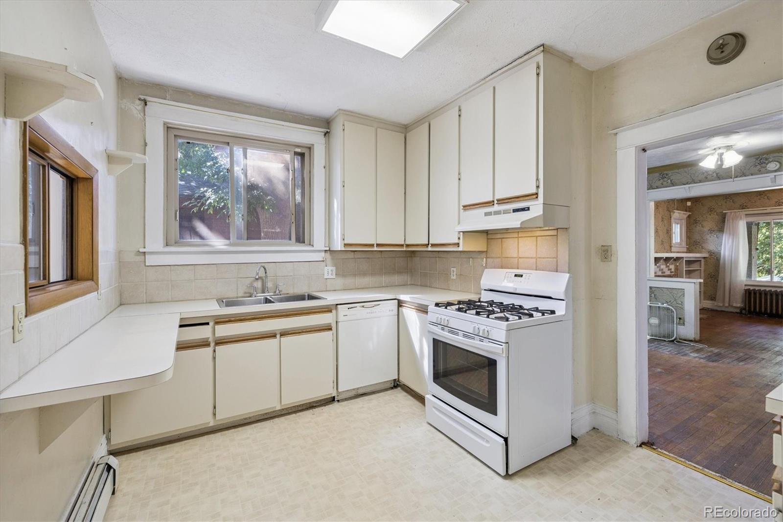 2510 Cherry Street Denver, CO 80207 - Photo 15 of 45 a kitchen with stainless steel appliances granite countertop a stove a sink and a microwave