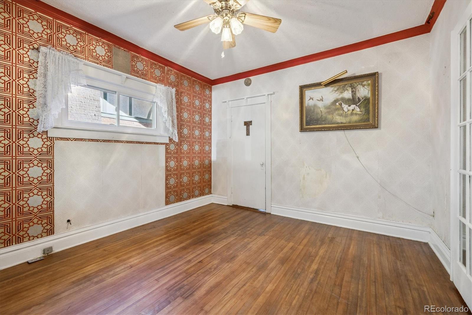 2510 Cherry Street Denver, CO 80207 - Photo 22 of 45 a view of an empty room with wooden floor and a window