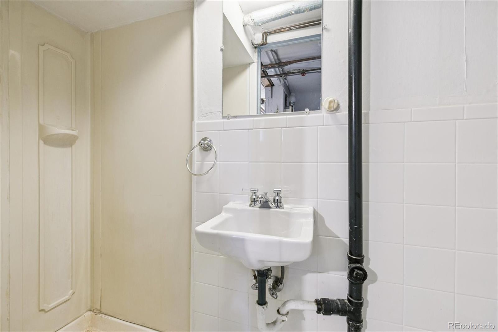 2510 Cherry Street Denver, CO 80207 - Photo 31 of 45 a bathroom with a sink a mirror and vanity