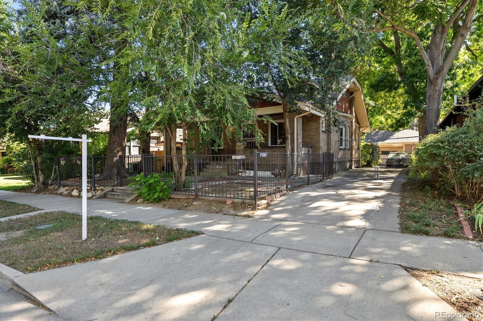 2510 Cherry Street Denver, CO 80207 - Photo 6 of 45 a front view of a house with a yard and potted plants