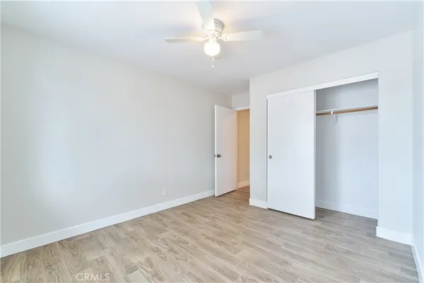 an empty room with a ceiling fan and a window