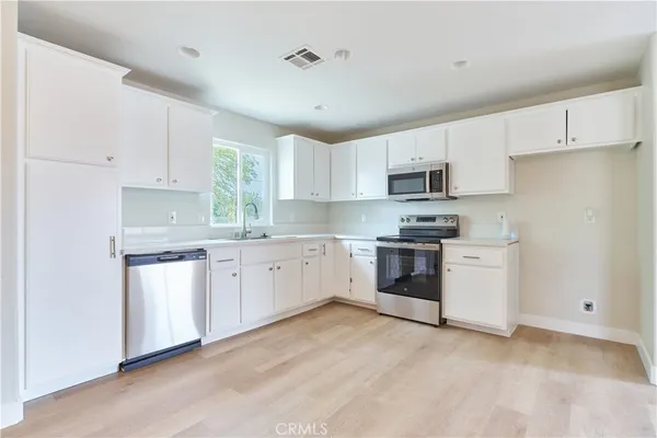 a kitchen with granite countertop white cabinets and white appliances