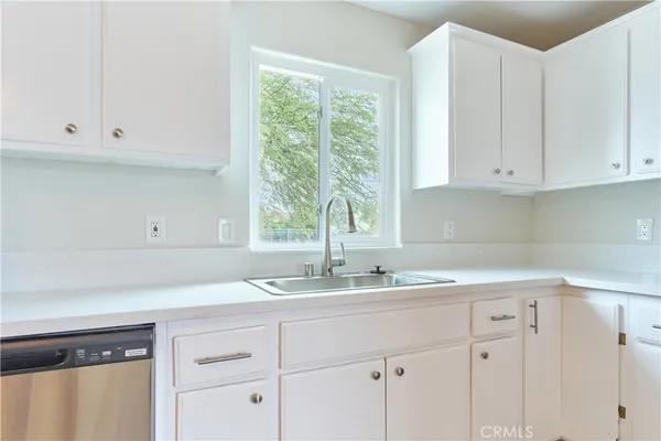 a kitchen with granite countertop white cabinets and a window
