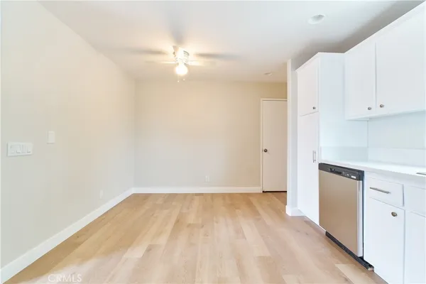 wooden floor in an empty room with a kitchen