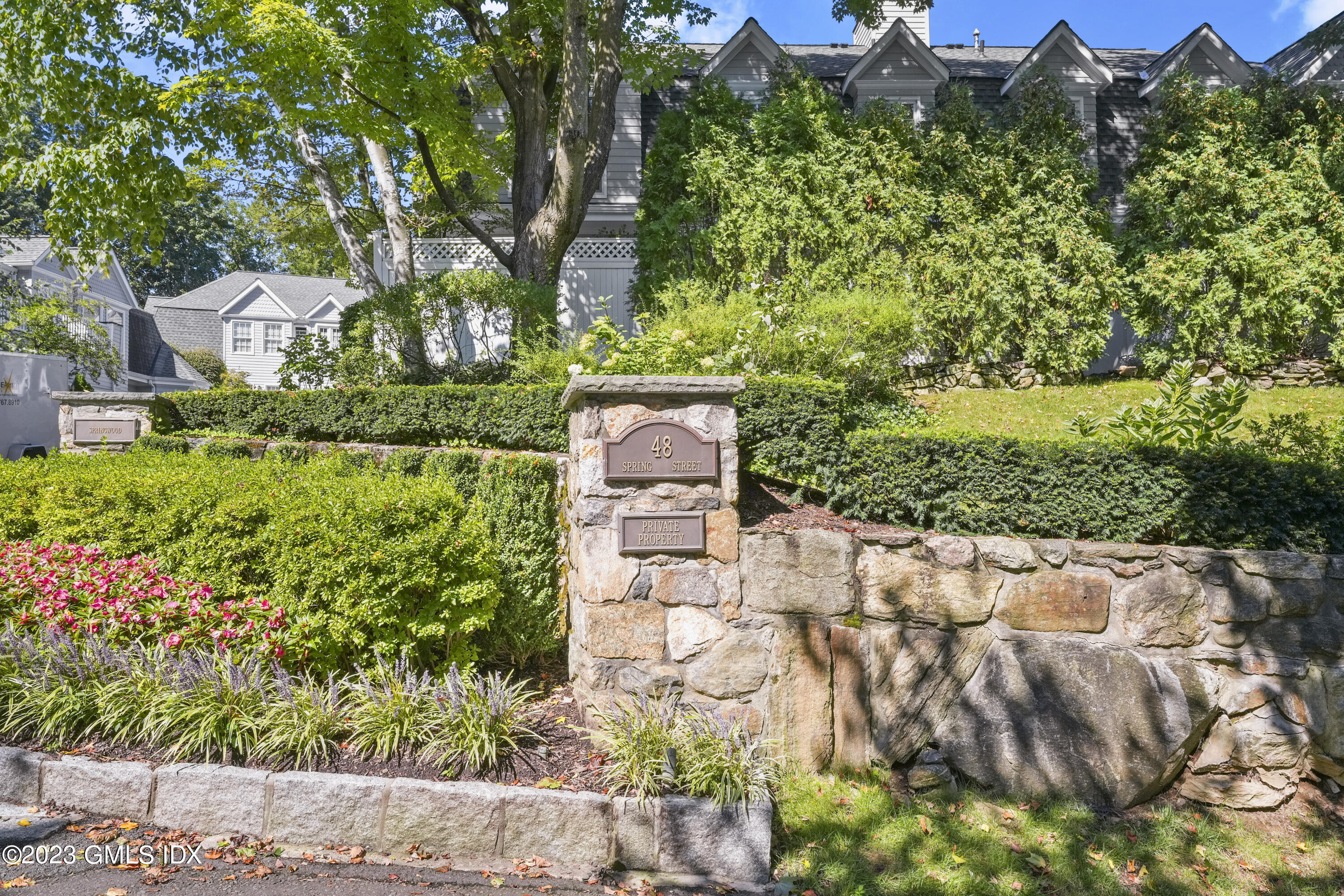 48 Spring Street, Unit 14 Greenwich, CT 06830 - Photo 26 of 29 a view of a garden with a bench