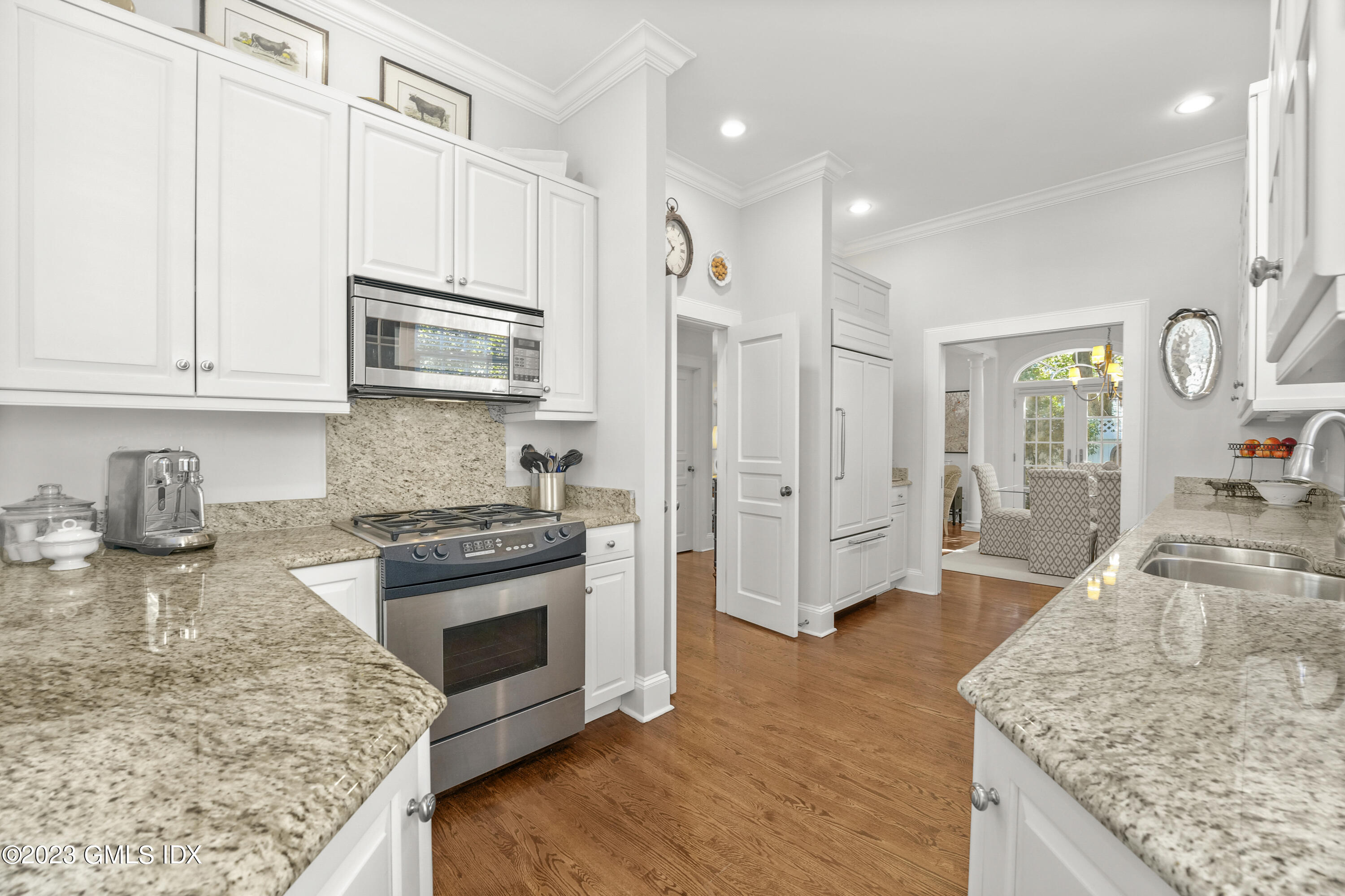 48 Spring Street, Unit 14 Greenwich, CT 06830 - Photo 8 of 29 a kitchen with stainless steel appliances granite countertop a stove top oven a sink a refrigerator white cabinets and wooden floor