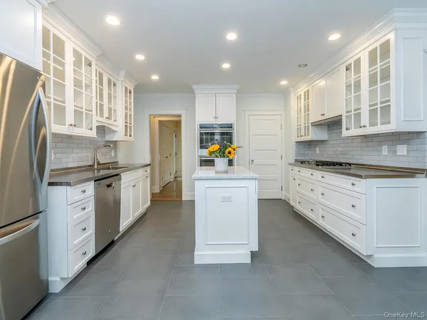 a kitchen with stainless steel appliances a refrigerator sink and cabinets