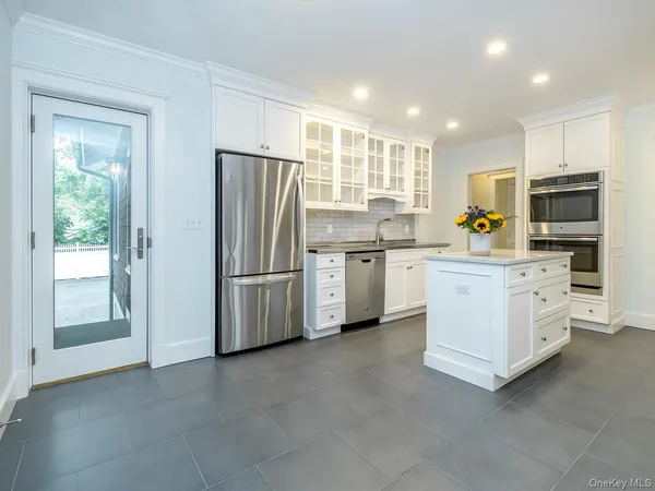 a kitchen with white cabinets and stainless steel appliances