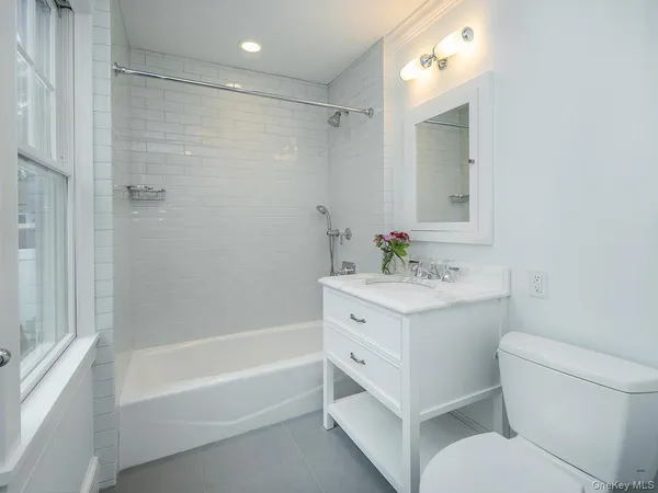 a bathroom with a sink toilet vanity and shower