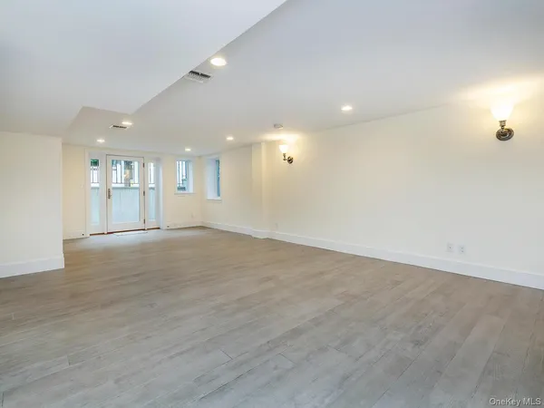 an empty room with windows and cabinet