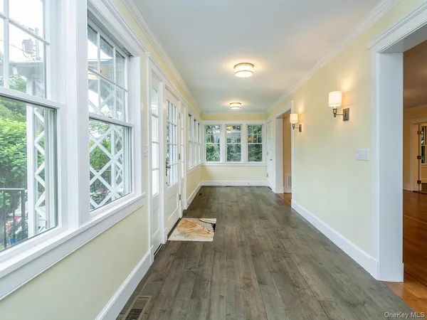a view of an entryway with wooden floor and a livingroom