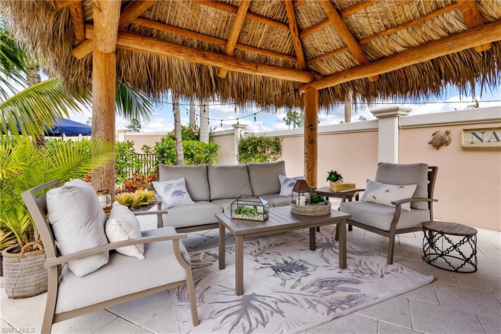 13595 Snook Circle Naples, FL 34114 - Photo 14 of 35 a view of a patio with couches and table and chairs with potted plants