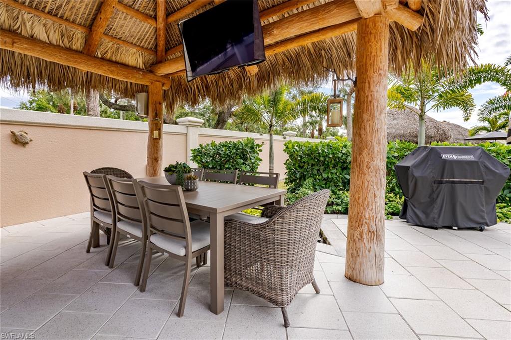 13595 Snook Circle Naples, FL 34114 - Photo 15 of 35 a view of a patio with table and chairs and potted plants