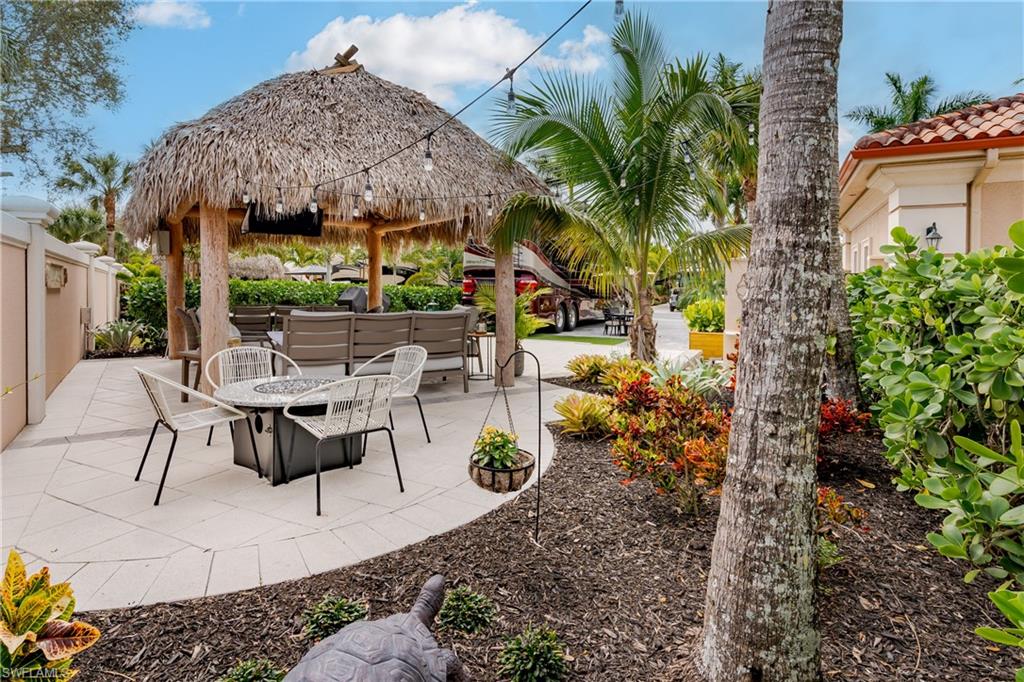13595 Snook Circle Naples, FL 34114 - Photo 19 of 35 a view of a patio with table and chairs potted plants
