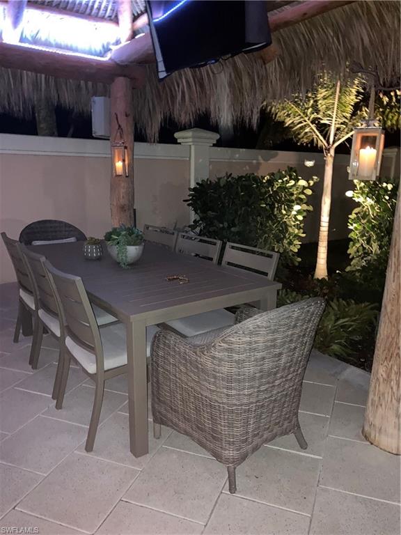13595 Snook Circle Naples, FL 34114 - Photo 26 of 35 a patio with a table and chairs