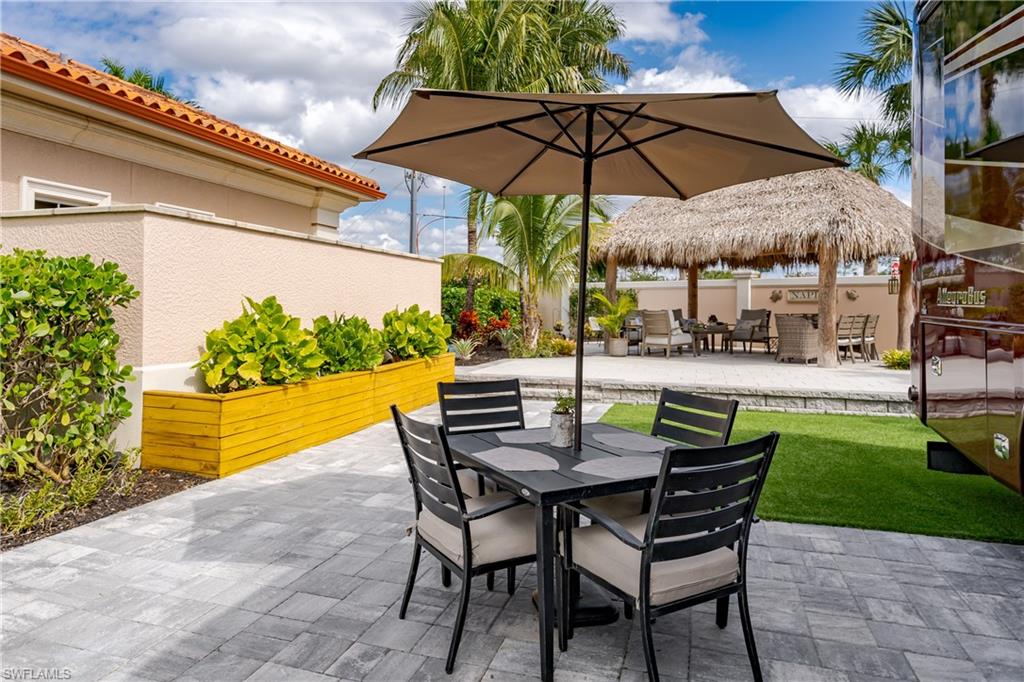 13595 Snook Circle Naples, FL 34114 - Photo 6 of 35 a view of a patio with a table and chairs under an umbrella