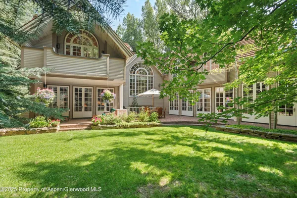 a front view of a house with a garden and trees