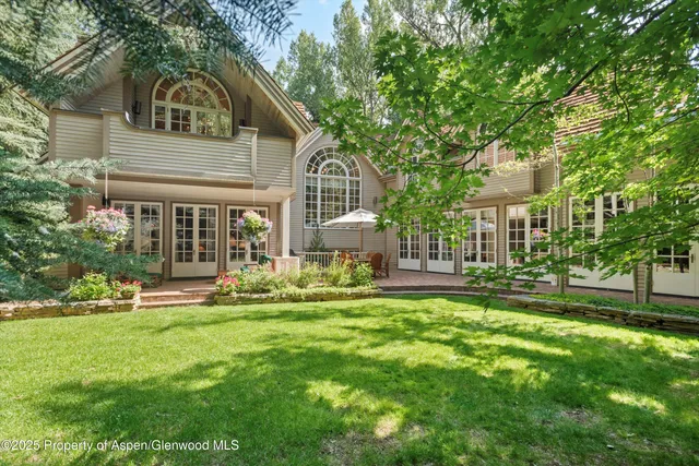 a front view of a house with a garden and trees